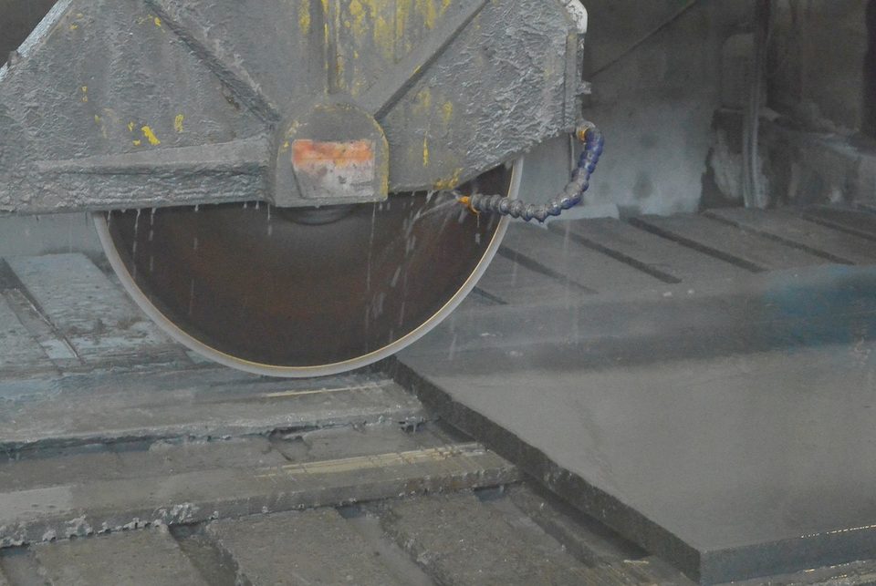 Stone saw cutting a countertop slab in a fabrication shop